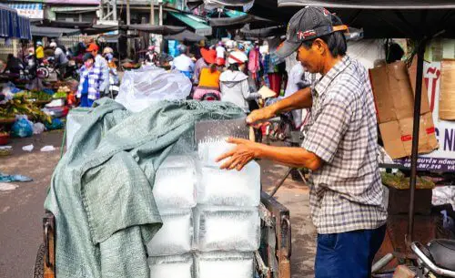Man Hanlding large block of ice without gloves
